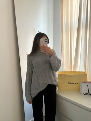 Grå kabelstickad tröja med hög krage - Säljer en grå oversize stickad tröja med kabelstickat mönster och hög krage. Inga synliga defekter! Kom med prisförslag!