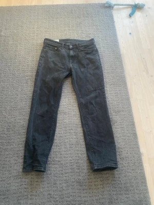 Svarta straight fit jeans - Säljer ett par svarta jeans med rak passform och klassisk femficksdesign. Jeansen har normal midja och är tillverkade i denim. Perfekta för dig som gillar en enkel och stilren look.