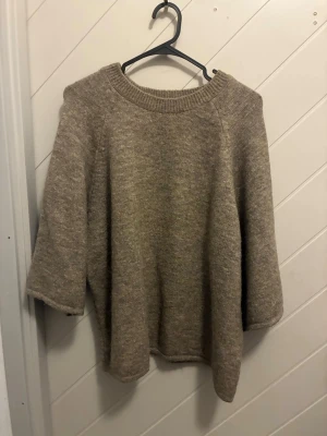  stickad tröja Gina Tricot - Mysig beige stickad tröja från Gina Tricot med rund halsringning och trekvartsärmar. Tröjan har en avslappnad passform. Knappt använd så i fint skick!!🤩