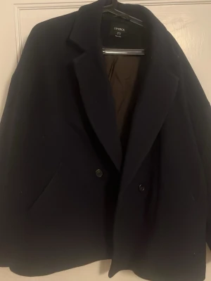 Mörkblå dubbelknäppt rock Lindex - Fin mörkblå kappa från Lindex för hösten/vären