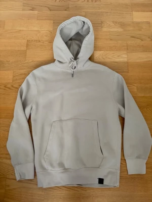 Beige hoodie med magficka - Snygg beige hoodie med stor magficka och dragsko i huvan från PULL & BEAR. Klassisk passform och ribbade muddar vid ärmslut och nederkant. Perfekt för en chill och avslappnad stil. Materialet känns mjukt och skönt mot huden. Storlek XS men sitter som en S. Pris kan alltid diskuteras✅. Hoodies har däremot en mindre defekt vilket är att en av silverringarna vid kragen sitter lite löst men inget man egentligen märker av, men därav det låga priset. Tveka inte på att höra av dig vid frågor!