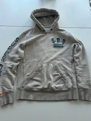 Super dry hoodie - En unik och snygg hoodie från super dry. Hoodien är i storlek xl men passar L. Va inte rädd för att ställa frågor!!