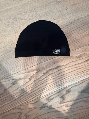 Syna world mössa - Syna world mössa svart aldrig använd helt nyskick.