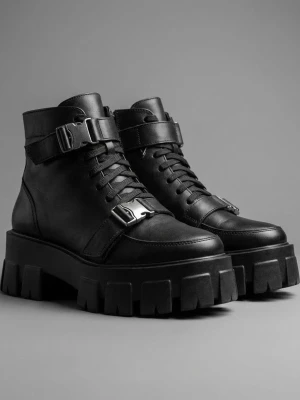 Chunky svarta stövletter med spännen - Säljer ett par svarta chunky stövletter i skinnimitation med grov sula, snörning och coola metallspännen. Skorna har dragkedja på insidan för enkel påtagning och en edgy look som sticker ut. Perfekta för dig som gillar streetstyle och vill ha något extra.