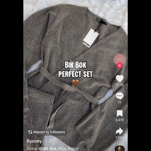 Grå omlottkofta från Bik Bok - Mysig grå omlottkofta från Bik Bok med knytband i midjan och långa ärmar. Koftan har en avslappnad passform och är tillverkad i ett mjukt, stickat material som känns skönt mot huden. Perfekt för en chill och trendig look. Koftan är slutsåld. Storlek xs. Använd endast 1 gång 