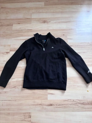 Svart merinoull halfzip J Lindeberg  - Snygg svart stickad tröja från J.Lindeberg med 100% Merinoull, tröjan är i storlek xl men det är barnstorlek så den motsvarar en Xs i vuxenstorlek. Pris kan diskuteras vid snabb affär 