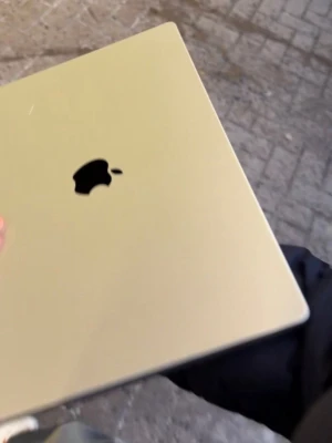 MacBook Air i guld från Apple - Snygg och tunn MacBook Air i guld med stilren aluminiumdesign. Datorn har ett stort trackpad, svart tangentbord och den klassiska Apple-loggan på locket. Perfekt för plugget eller kreativa projekt.