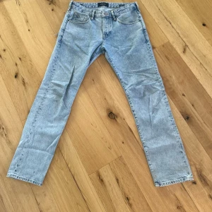 Ljusblå jeans från Scotch & Soda - Säljer ett par ljusblå jeans från Scotch & Soda i modellen Vernon. Jeansen har rak passform, klassisk femficksdesign och är tillverkade i ekologisk bomull. Perfekta för en avslappnad och trendig look. 