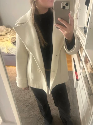 Vit/beige kappa från design by si  - Jättefin vit/beige kappa från design by si. Perfekt nu till våren och är i storlek xs/s.