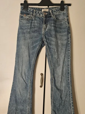 Blå bootcut jeans med broderade fickor - Snygga blå bootcut jeans från Lindex med broderade fjärilar på bakfickorna. De är lågmidjade och har ingen slitage alls. De är precis som nya. Nästan aldrig använda