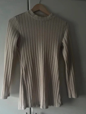 Beige ribbad långärmad topp, set med byxor - Snygg beige ribbad topp med lång ärm och högre rundad hals. Materialet är stretchigt och mjukt, vilket ger en skön passform. Perfekt att styla med jeans eller kjol för en clean look. För fler bilder/information skriv gärna, priset kan justeras 🤗❤️