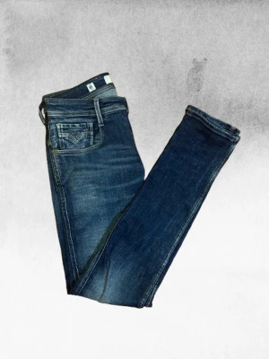 Mörkblå Slim Fit Jeans Replay Anbass - Den populära modellen Anbass i mörkblå slim fit jeans från Replay med klassisk femficksdesign och en snygg tvätt. Jeansen har provats 1-2 gånger och är i princip helt nya. Köptes för 1700 men kände att det inte passade min stil. Storlek 29/34 som sitter lite för långt för mig där det kavlar ihop runt foten, jag är 178 cm.