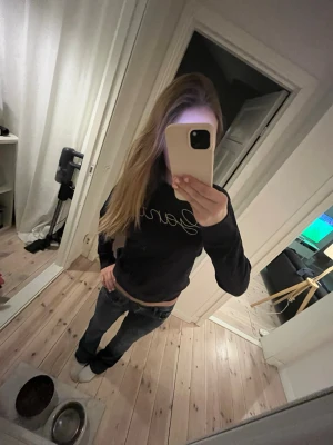 Marinblå sweatshirt från Gant - Marinblå sweatshirt från Gant med guldfärgat broderat logotyp på bröstet. Tröjan har rund halsringning, långa ärmar och ribbade muddar vid ärmslut och nederkant. 