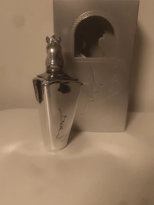 Maahir parfym silverflaska 100ml - Lyxig parfym från Maahir i en unik silverfärgad flaska med hästhuvud som kork. Flaskan har en elegant och modern design med arabiska detaljer och levereras i matchande silverfärgad förpackning. Använd max 10 spray