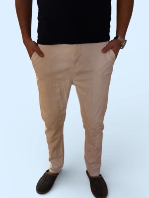 Vita chinos - Snygga beiga chinos med smal passform och klassisk design. Byxorna har två sidofickor fram och två passpoalfickor bak. Tillverkade i ett lätt och bekvämt material som passar perfekt till en avslappnad stil. Inga synliga loggor eller märken.