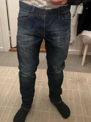 Mörkblå jeans från Costume National - mörkblå jeans från Costume National med snygga slitningar och klassisk femficksmodell.