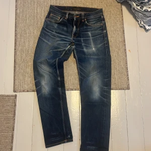 Selvedge jeans från Nudie Jeans - Säljer ett par mörkblå jeans från Nudie Jeans med selvedge material i modellen gritty jackson. Hål i skrevet men finns att laga gratis hos Nudie. Det syns inte när man står upp eftersom det är under. Sjukt fet tvätt som bara blir bättre med användning 