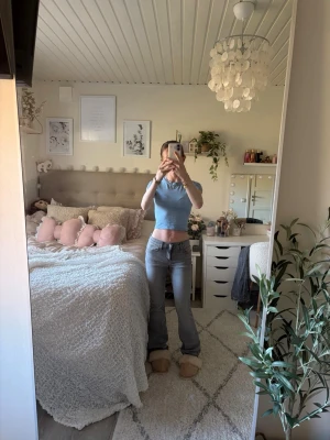 Grå bootcut jeans med låg midja - Snygga grå bootcut jeans med låg midja och klassiska fem fickor. Jeansen har en lätt tvättad look och raka ben som blir vidare nedtill. Perfekta för en trendig och avslappnad stil.