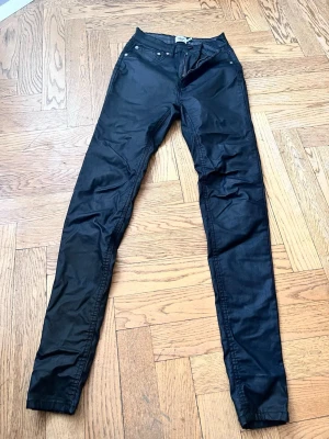 Svarta skinny jeans  - Säljer ett par svarta skinny jeans med klassisk femficksdesign och låg midja. Jeansen har smal passform hela vägen ner och är tillverkade i stretchigt material för extra komfort. Perfekta för en trendig och avslappnad stil.