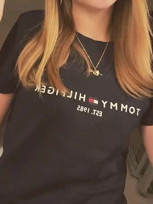 Marinblå Tommy Hilfiger t-shirt - Snygg marinblå t-shirt från Tommy Hilfiger med klassisk logga och texten 'EST. 1985' broderat på bröstet. T-shirten har rund halsringning och korta ärmar. Perfekt till jeans eller shorts för en clean och stilren look.
