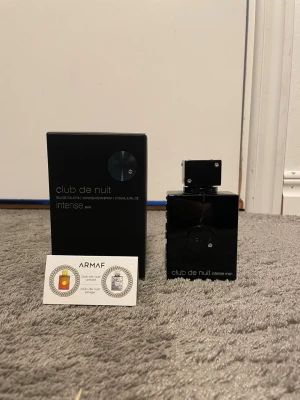 Club de Nuit Intense Man Eau de Toilette - Club de Nuit Intense Man från Armaf är en parfym med en elegant svart, fyrkantig flaska och matchande svart kartong. Flaskan har silverdetaljer och en robust design. Doften är känd för sina intensiva och maskulina noter, perfekt för dig som vill sticka ut.