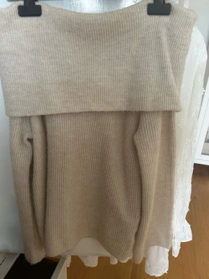 Beige off shoulder stickad tröja - Säljer en beige ribbstickad off shoulder-tröja från H&M. Säljer då den inte kommer till användning längre. Skriv vid minsta fråga.