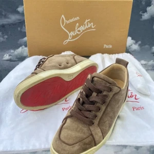Louboutin (bruna) - Snygga sneakers från Christian Louboutin i brun mocka med klassisk röd sula och bruna snören. Skick 8/10 finns tecken på användning, sitter extremt bra, storlek 40,5, bara skorna ingår, fraktar direkt, skriv vid intresse av köp!