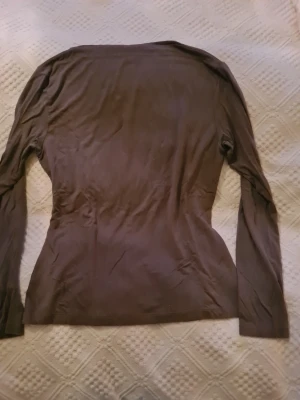 Grön långärmad topp från Mari Philippe - En grön långärmad topp från Mari Philippe med figurnära passform. Tillverkad i mjukt material som känns skönt mot huden. Perfekt att styla med jeans eller kjol för en enkel och snygg look.