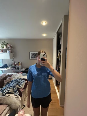 Blå stickad topp med puffärm - Snygg blå stickad topp med korta puffärmar och rund hals. Toppen har ett fint hålmönster och känns både trendig och bekväm. Perfekt att styla med jeans eller kjol för en cool look.