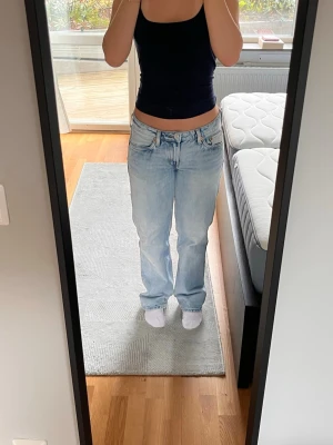 Ljusblå raka jeans från Weekday - Säljer ett par ljusblå jeans med rak passform och låg midja. Jeansen har klassiska fem fickor och bälteshällor. Perfekta för en avslappnad och trendig look. Materialet är denim i bomull. 