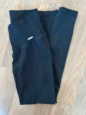 Svarta ribbade träningstights Aim’n  - Svarta ribbade träningstights med hög midja. Fint skick förutom att dom är något blekare än nya.