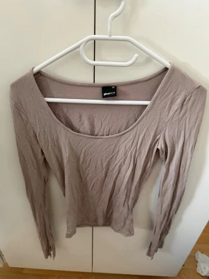 Beige långärmad topp Gina Tricot - Säljer en enkel och stilren beige långärmad topp från Gina Tricot. Toppen har rund halsringning och är tillverkad i mjuk bomull, perfekt att matcha med jeans eller kjol.