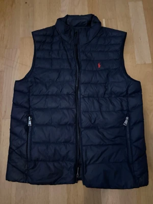 Svart dunväst från Ralph Lauren - Svart Ralph lauren väst i mycket bra skick. Inga hål eller rivor. Storlek s