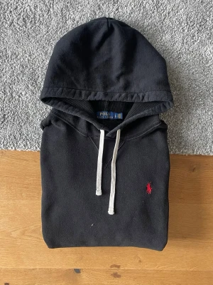 Svart hoodie från Polo Ralph Lauren - Svart Ralph Lauren hoodie i storlek L säljes. I mycket bra skick och utan defekter. Stilren och bekväm hoodie som passar perfekt till vardags.  ✅ Storlek L ✅ Mycket bra skick ✅ Inga defekter ✅ Snabb frakt  Hör gärna av er vid frågor eller om ni vill ha fler bilder!
