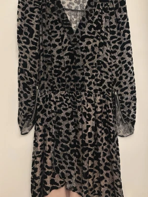 Leopardmönstrad klänning Zadig & Voltaire - Leopardmönstrad klänning från Zadig & Voltaire i svart och grått. Klänningen har v-ringning, långa ärmar och dragkedjor vid ärmsluten. Tillverkad i ett mjukt, sammetsliknande material som ger en lyxig känsla.