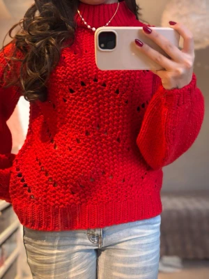 Röd stickad tröja med polokrage - Snygg röd stickad tröja med polokrage och luftigt mönster. Tröjan har långa ärmar med breda muddar och en loose passform som ger en chill vibe. Perfekt att matcha med jeans för en cool look.