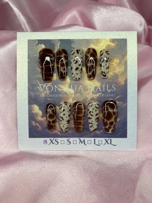 Feral (XS); Medium Ballerina - Unika handgjorda press-on naglar i brunt och beiget med coola djurmönster. Naglarna har en medium längd, ballerinaform design och är i  XS: 14 mm, 11 mm, 11,5 mm, 10 mm, 8 mm . Perfekt för dig som vill sticka ut med trendiga och kreativa naglar.