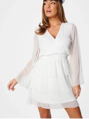 Vit klänning med volanger - Säljer en vit kortklänning med v-ringning. Klänningen har långa transparenta ärmar och flera lager volanger på kjolen. Aldrig använd och prislapp finns.