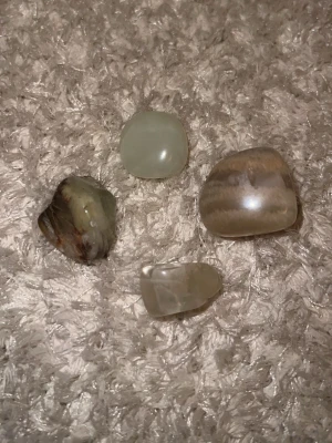 Polerad månsten i beige nyans - Säljer polerade månstenar i beige och krämvit ton. Starna har en mjuk, rundad form och skimrar vackert i ljuset. Perfekt som dekoration eller till smyckestillverkning. Unik och naturlig look!