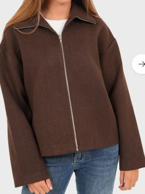 Brun ulljacka med dragkedja - Stilren brun jacka/kappa med rak passform och lång ärm. Jackan har en klassisk krage och hel dragkedja. Jackan är lite tjockare i material så den ger mycket värme utan att se pösig ut över huvud taget. Jackan är helt ny och nypris är ca 900kr. Mitt pris 650kr. Jackan passar från storlek xs till m beroende på önskad passform🤎