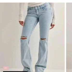 Ljusblå bootcut jeans nelly - Snygga ljusblå jeans med bootcut passform och slitna detaljer vid knäna. Jeansen har klassisk femficksdesign, låg midja och är tillverkade i mjukt denimtyg. Perfekta för dig som gillar en avslappnad och trendig stil.