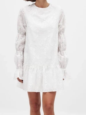 Vit broderad kortklänning med volang - Söt vit kortklänning med broderade blommor, volangkant nedtill och transparenta långärmar. Klänningen har öppen rygg med knytband och en avslappnad passform. Perfekt för sommarens alla tillfällen.