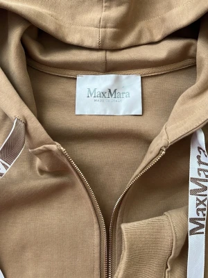Max Mara Beige loungewear-set  - Mysigt loungewear-set från MaxMara i beige bomull. Setet består av en hoodie med dragkedja, fickor och vita snören med logga samt en matchande t-shirtklänning med samma snördetalj. Perfekt för chill dagar hemma. Storlek XL passar även S M L Köpt i Japan för 4500kr på vintage.