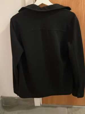 Svart rock i ullblandning XS - Fin kofta med knappar från h&m. Aldrig använt. Storlek xs med den är lite overize så kanske typ som en storlek S. Väldigt skön att ha på. Passar bra till kalas, fester osv. Hör av dig vid flera frågor!