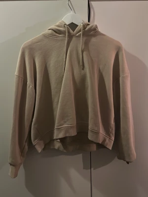 Beige hoodie från 157 med huva - Säljer en beige hoodie från 157 i storlek M. Hoodien har en klassisk huva med dragsnören och ribbade muddar vid ärmar och nederkant. Perfekt oversized passform och mjukt material som känns skönt mot huden. Enkel och stilren design som passar till det mesta.