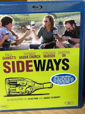 Blu-ray Sideways - Säljer Blu-ray-utgåva av filmen Sideways, en komedi om två vänner på vinresa i Kalifornien. Omslaget är blått med gul framsida och motiv av fyra personer som skålar med vin. Extramaterial som borttagna scener och bakom kulisserna ingår.