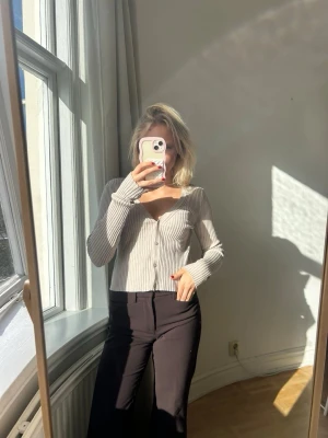 Beige ribbad kofta med knappar💖💖✨ - Säljer en beige ribbad kofta med v-ringning och långa ärmar. Koftan har en figurnära passform och stängs med knappar framtill. Perfekt att styla med både jeans och kjol för en trendig look.