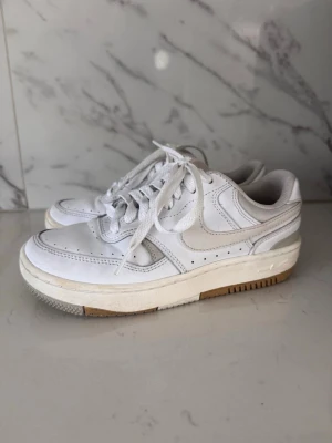 Nike Gamma Force, vit/creme, strl 35.5 - Nike Gamma Force – vit.      Säljer mina Nike Gamma Force då de inte kommer till användning. Köpta på Zalando för 1149 kr (ordinarie pris, ligger fortfarande kvar på samma pris). Använda ett fåtal gånger förra sommaren – vissa tecken på användning finns, men överlag i fint skick.                             Perfekta till student, skolavslutningar eller vardags. Nypris: 1149 kr. Öppen för affärer, skickar snabbt. Orginal skokartongen är slängd men skickar i en annan Nike-kartong :) 