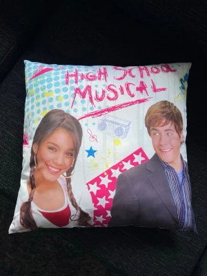 High School Musical-kudde, Disney original - Säljer en original High School Musical-kudde i mycket fint skick. Använd för flera år sedan. Perfekt för samlare eller fans ⭐️🎤 Innerkudden följer med om så önskas! 📏 Mått: 40x40cm (endast fodral, utan innerkudde). Kudden är sydd med en egen söm längst med nederkanten. Granska bilderna noggrant. 