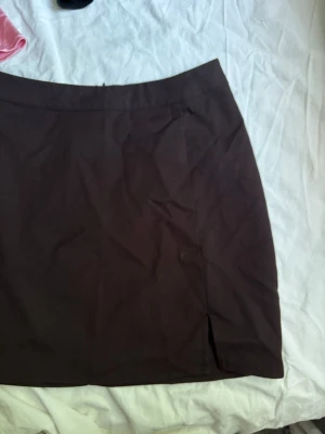 Brun kortkjol med slits - Snygg brun kortkjol med enkel design och liten slits framtill. Knappt använd